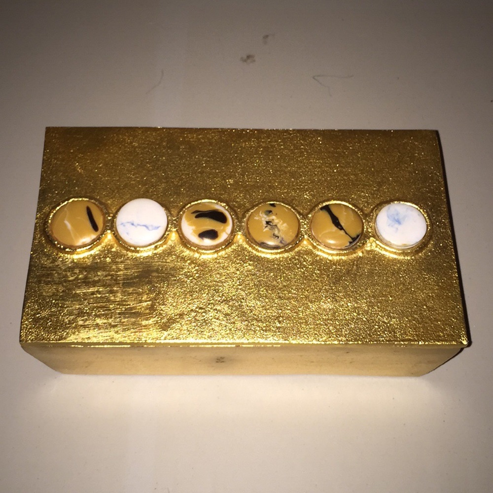 gold metal box with decorative discs on lid
